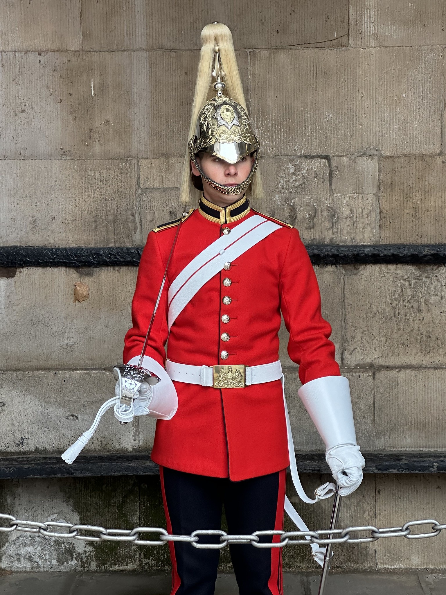 A member of the King's Guard in a bright red uniform and polished ceremonial helmet